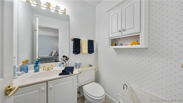 bathroom with vanity, toilet, ensuite bathroom, and wallpapered walls