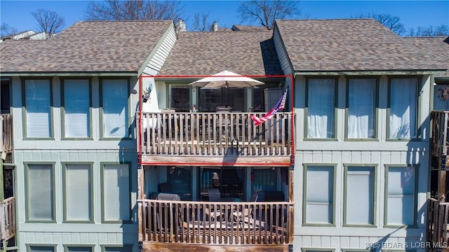 exterior space featuring board and batten siding and a shingled roof