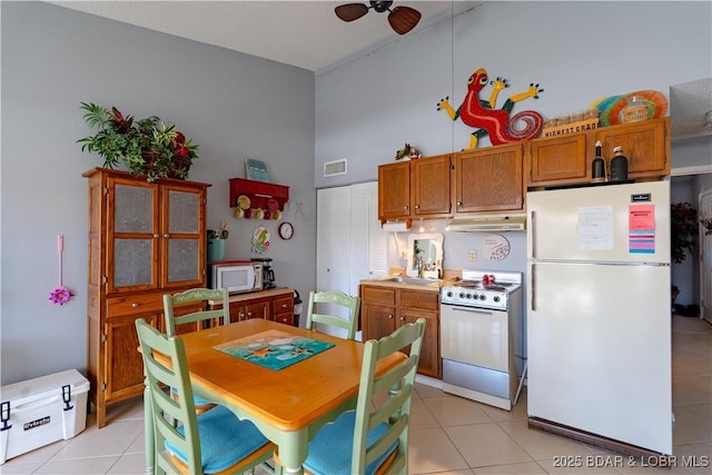 123 Southwood Shores Dr Unit 4C, Lake Ozark, MO 65049 - kitchen featuring white appliances, light tile patterned flooring, a high ceiling, ceiling fan, and brown cabinetry