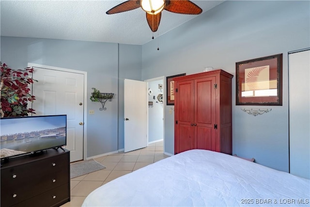 bedroom featuring light tile patterned floors, baseboards, a textured ceiling, and ceiling fan