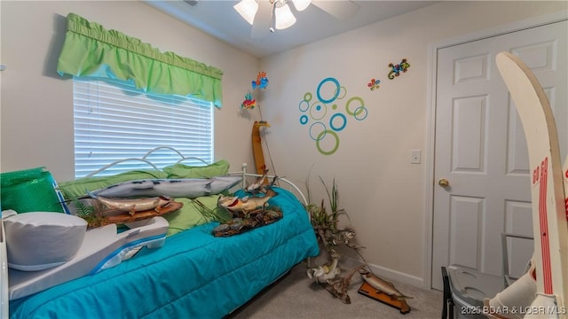 carpeted bedroom featuring baseboards and ceiling fan