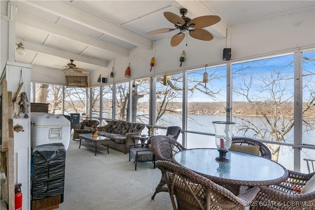 sunroom with lofted ceiling with beams, a ceiling fan, and a water view