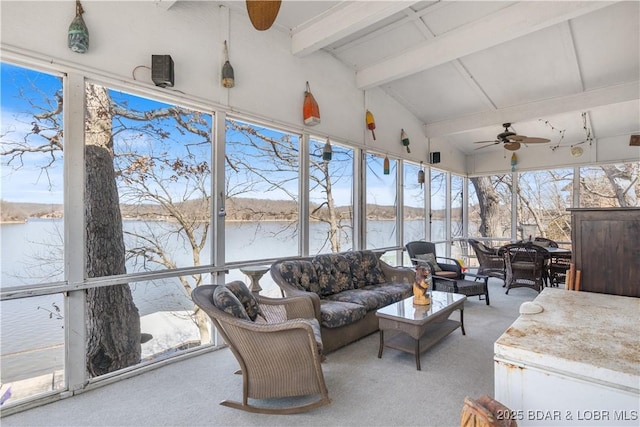 sunroom featuring lofted ceiling with beams, a ceiling fan, and a water view