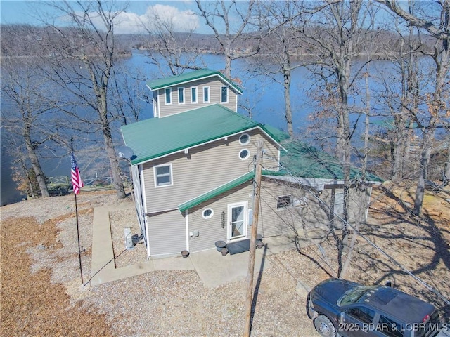 rear view of property featuring a patio and driveway