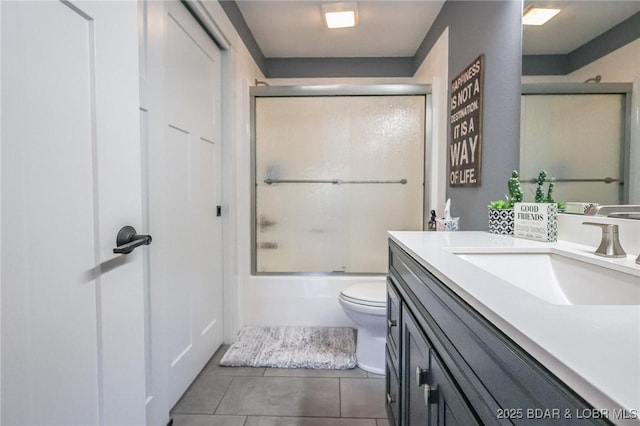 full bathroom with tile patterned floors, shower / bath combination with glass door, vanity, and toilet