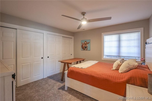 carpeted bedroom with multiple closets and a ceiling fan