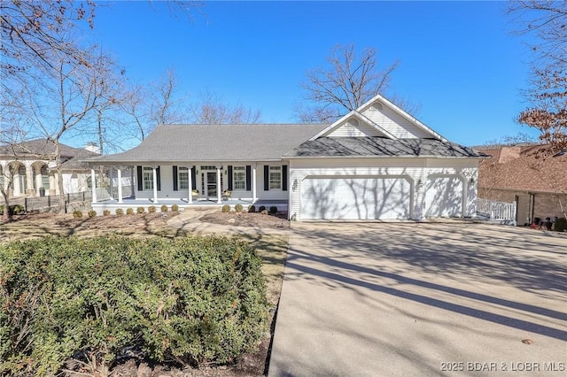 view of front of house with a porch, an attached garage, fence, and driveway