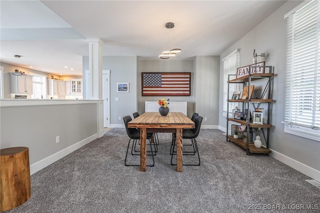 dining area with decorative columns, baseboards, carpet flooring, and radiator heating unit