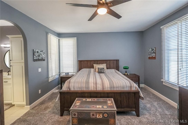 bedroom featuring arched walkways, a ceiling fan, carpet, and baseboards