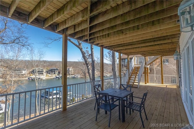 deck with stairway and a water view