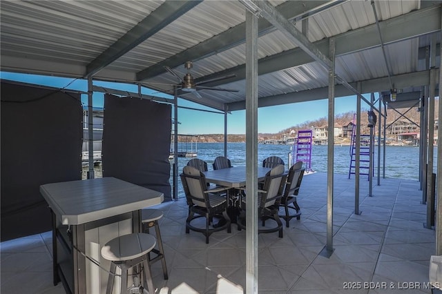 view of patio / terrace with ceiling fan, outdoor dining space, a water view, and a boat dock