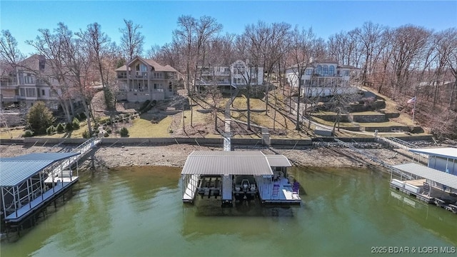 view of dock with a water view, a residential view, and boat lift