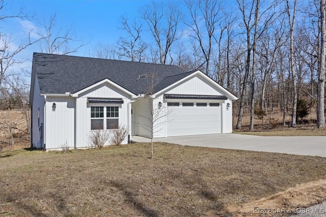 view of front facade with a garage, concrete driveway, a front yard, and a shingled roof