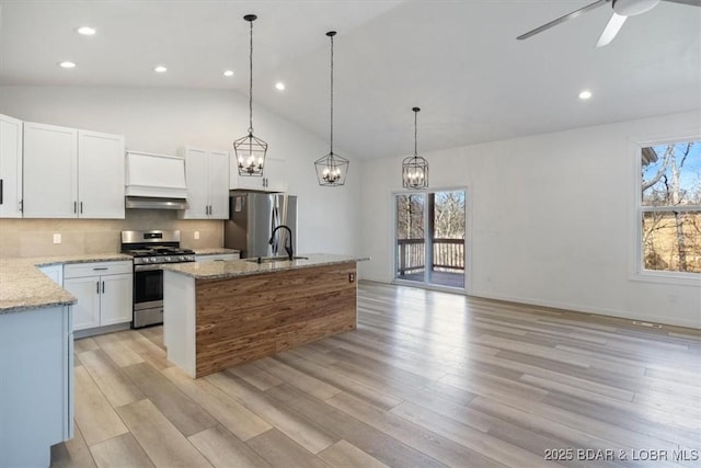 kitchen featuring a wealth of natural light, backsplash, appliances with stainless steel finishes, and ventilation hood