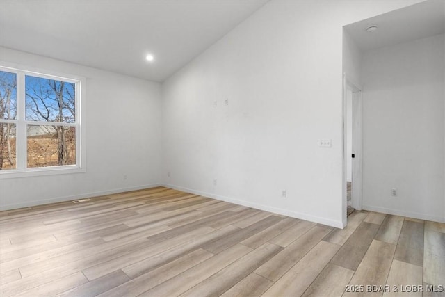 empty room featuring recessed lighting, baseboards, and light wood-style floors