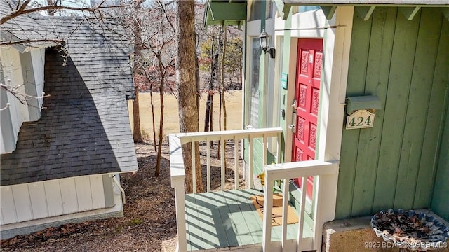 doorway to property with roof with shingles