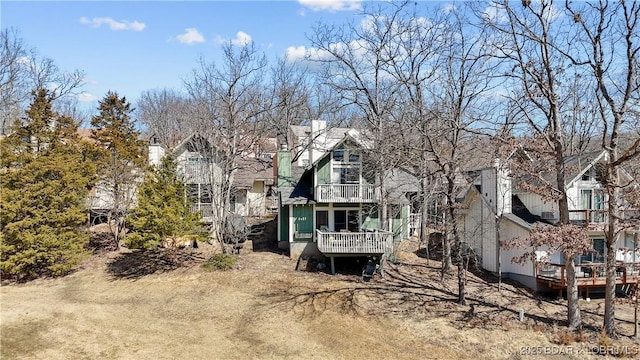 rear view of house with a wooden deck, a residential view, and a balcony