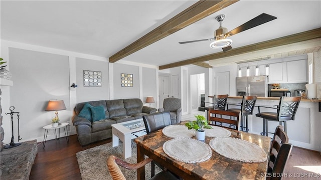 dining area with a ceiling fan, beam ceiling, and wood finished floors