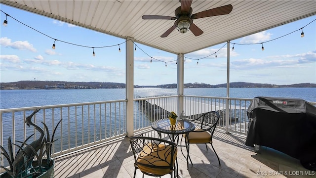 exterior space with ceiling fan and a water view