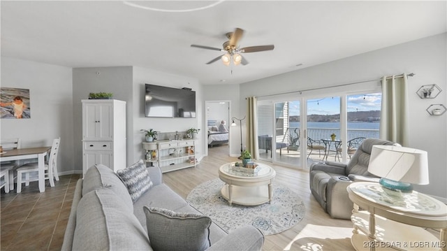 living area featuring wood finished floors, baseboards, and ceiling fan