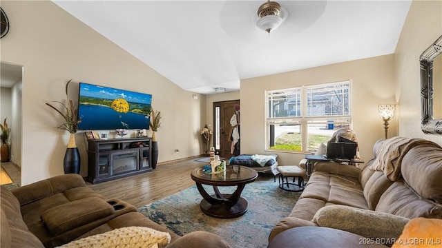 living room featuring ceiling fan, baseboards, wood finished floors, and vaulted ceiling