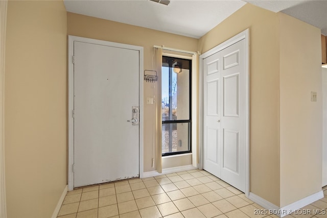 entrance foyer featuring light tile patterned floors and baseboards