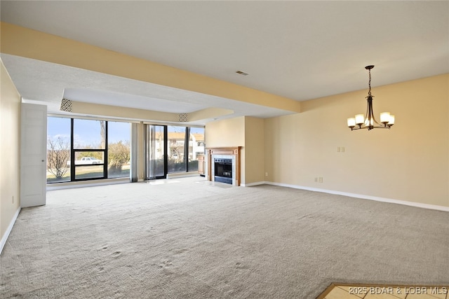 unfurnished living room with visible vents, baseboards, a chandelier, carpet flooring, and a fireplace