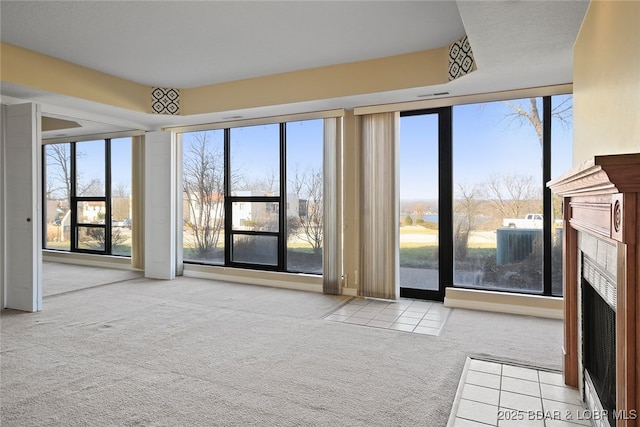 unfurnished living room with a fireplace and carpet