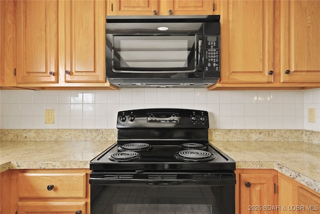 kitchen featuring black appliances, light countertops, and backsplash