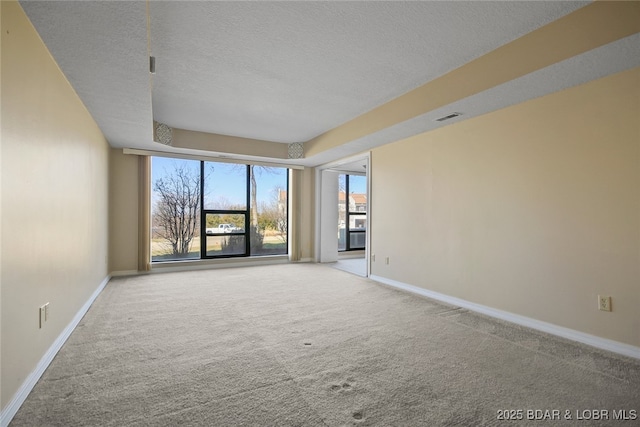 empty room with visible vents, carpet floors, a textured ceiling, and baseboards