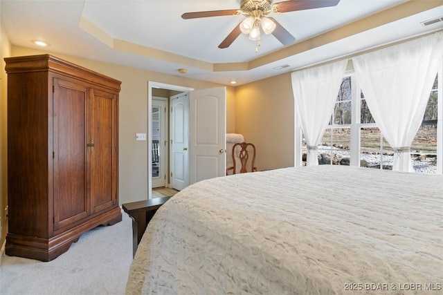 bedroom featuring recessed lighting, visible vents, a raised ceiling, and light carpet