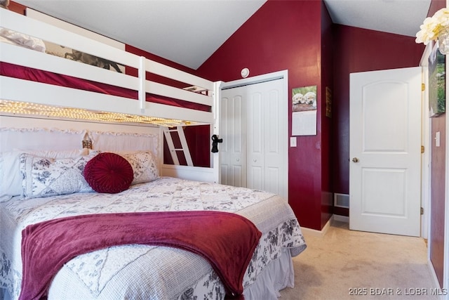 bedroom featuring a closet, visible vents, light colored carpet, and vaulted ceiling