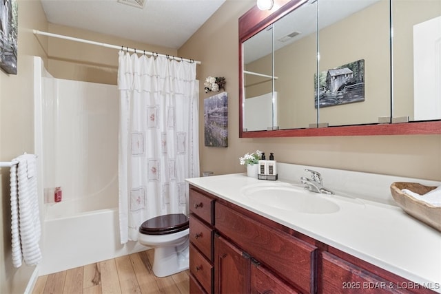 full bathroom featuring visible vents, toilet, shower / bath combo with shower curtain, wood finished floors, and vanity