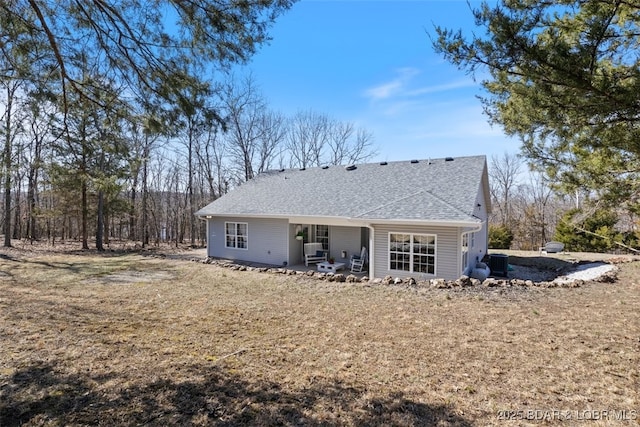 back of house with a patio, central AC, and roof with shingles