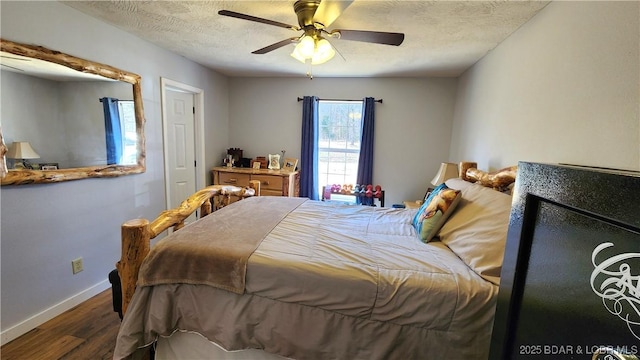 bedroom featuring ceiling fan, a textured ceiling, baseboards, and wood finished floors