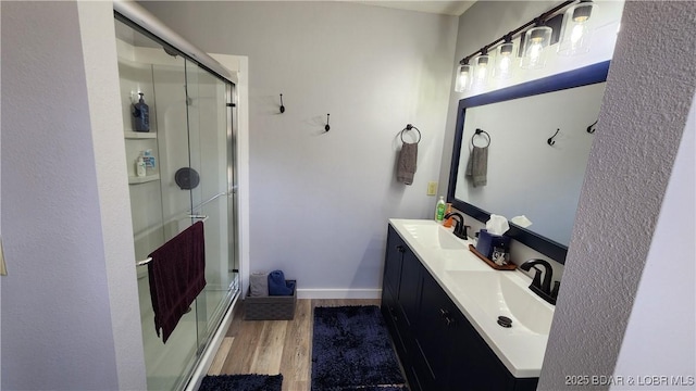 bathroom featuring a sink, a stall shower, and wood finished floors