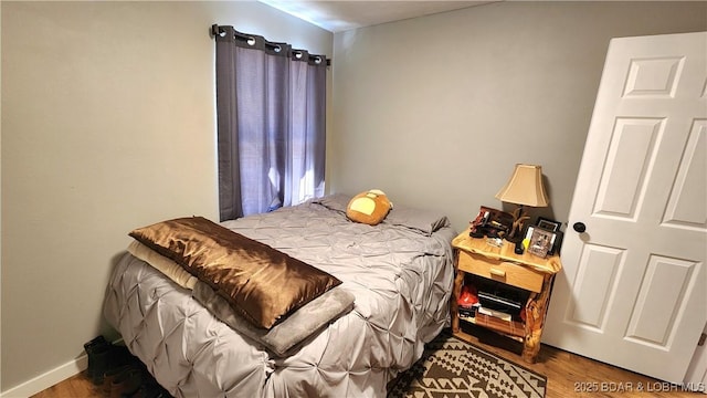 bedroom featuring baseboards and wood finished floors