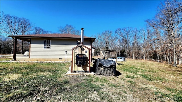 rear view of property featuring a wooden deck, a yard, and crawl space