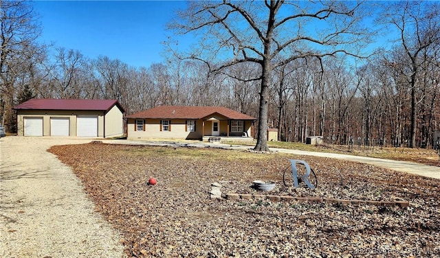 single story home featuring an outbuilding, a porch, and a garage