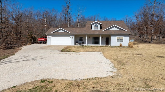 view of front facade featuring a porch, a garage, driveway, and a front lawn