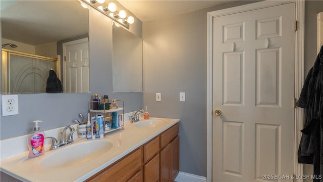 full bathroom with double vanity, a stall shower, and a sink