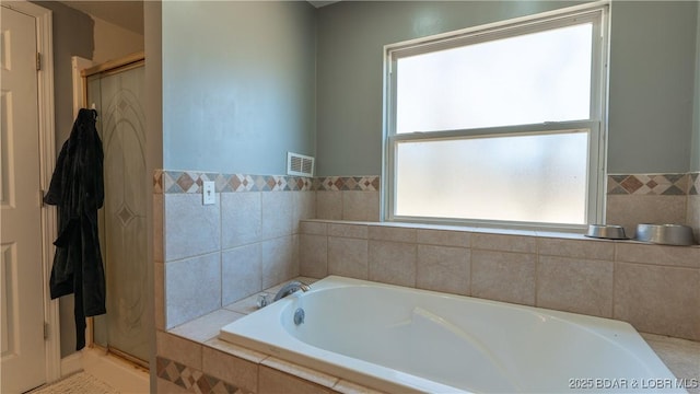 full bathroom featuring a bath, visible vents, and a stall shower