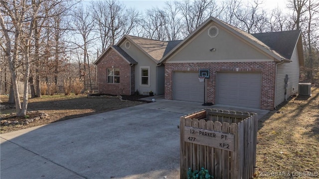 ranch-style house with brick siding, an attached garage, concrete driveway, and central AC