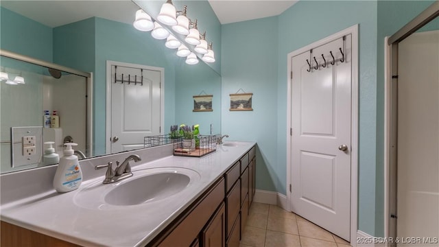 bathroom featuring tile patterned flooring, double vanity, baseboards, and a sink