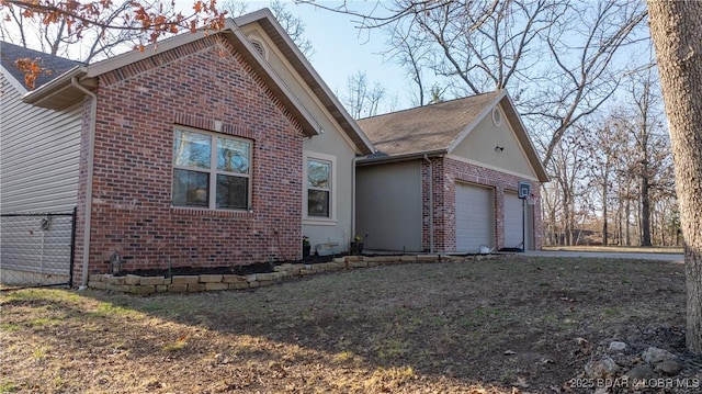 view of home's exterior featuring brick siding, driveway, and a garage