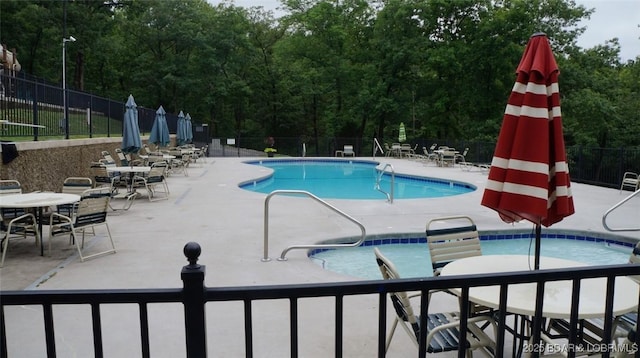 community pool featuring a patio and fence