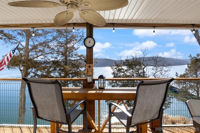 snow covered deck featuring a ceiling fan and a mountain view