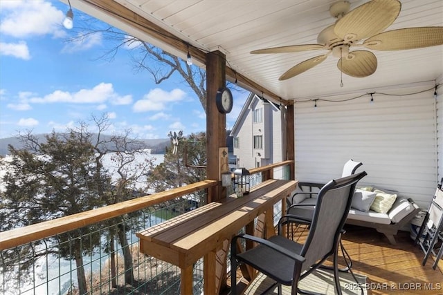 balcony with a ceiling fan and a water view