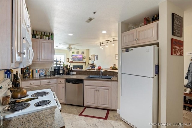 kitchen with ceiling fan, dishwasher, range with electric stovetop, freestanding refrigerator, and a sink