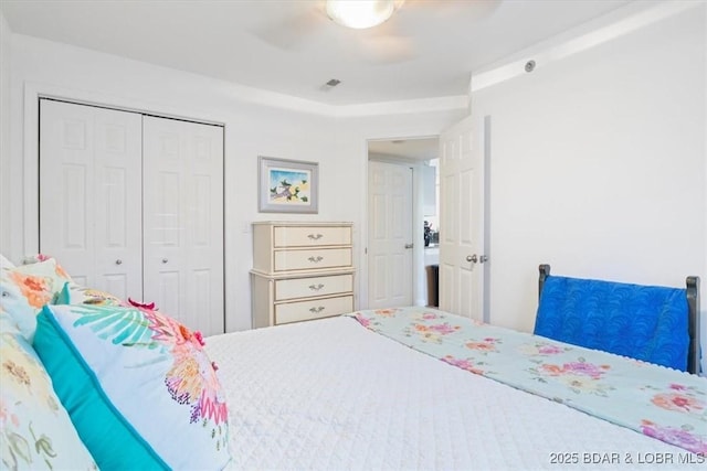 bedroom featuring a ceiling fan, visible vents, and a closet